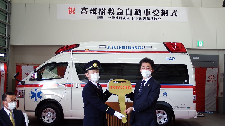 レプリカ—キーを贈呈する松山会長（右）と 受け取る須田消防長（左）