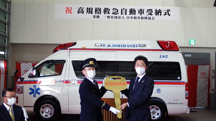 レプリカ—キーを贈呈する松山会長(右)と 受け取る須田消防長(左)
