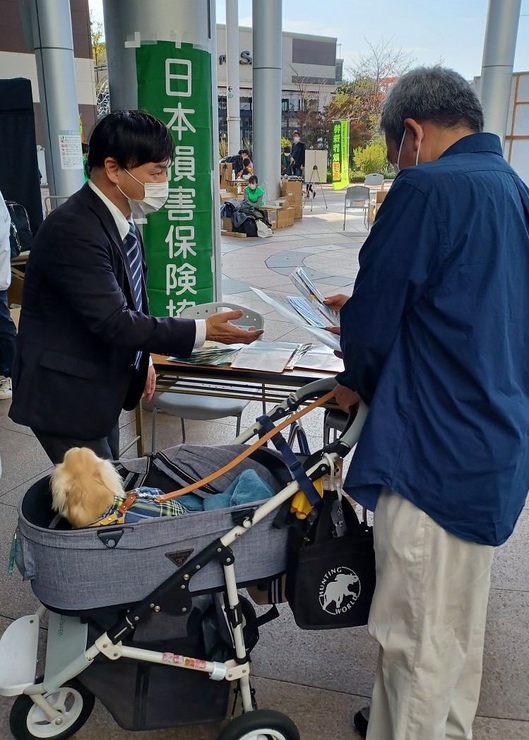 チラシを手渡す二ノ宮事務局長